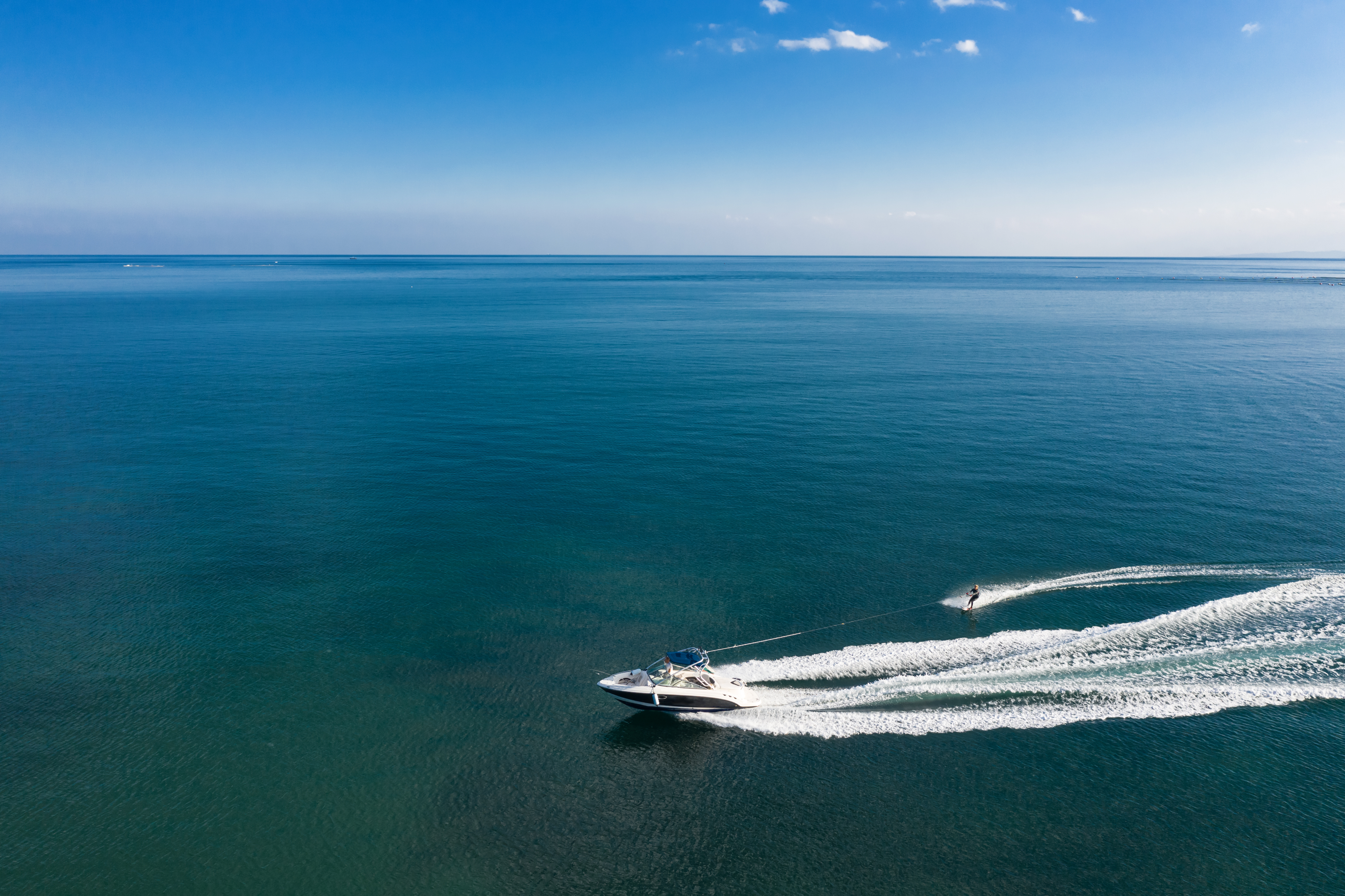 A boat pulls someone on a waterski, avoid drinking and boating concept. 