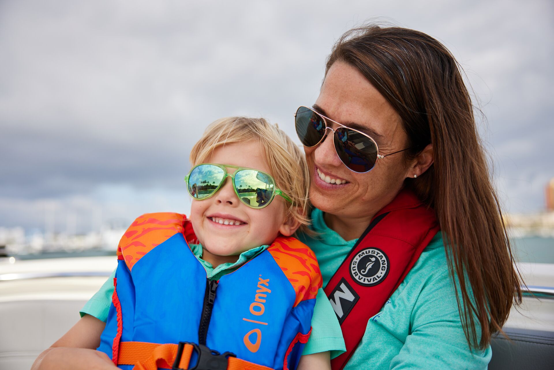 A smiling woman and child wearing life jackets on a boat, boat safety concept. 