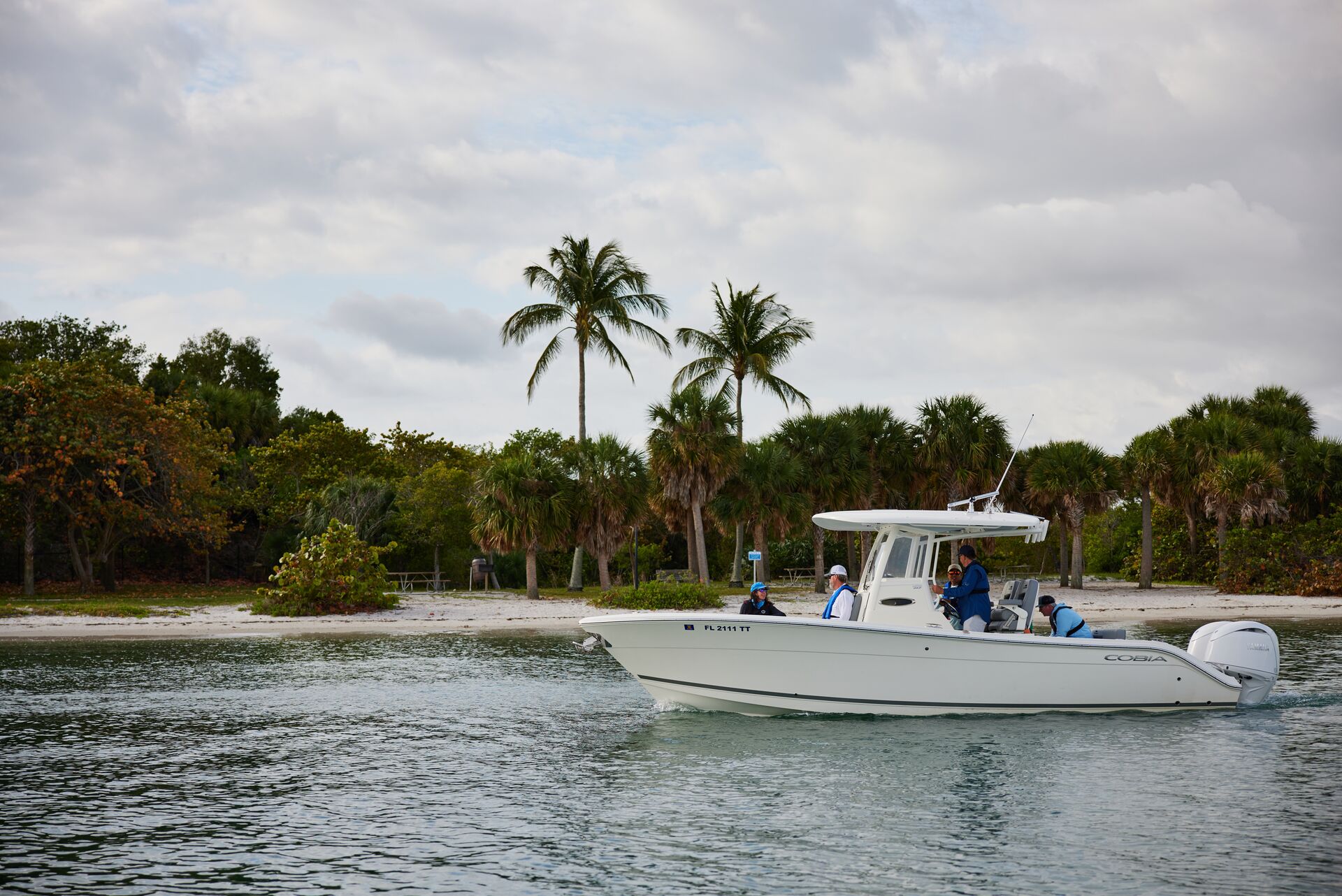 The port side of a boat on the water along the shore. 