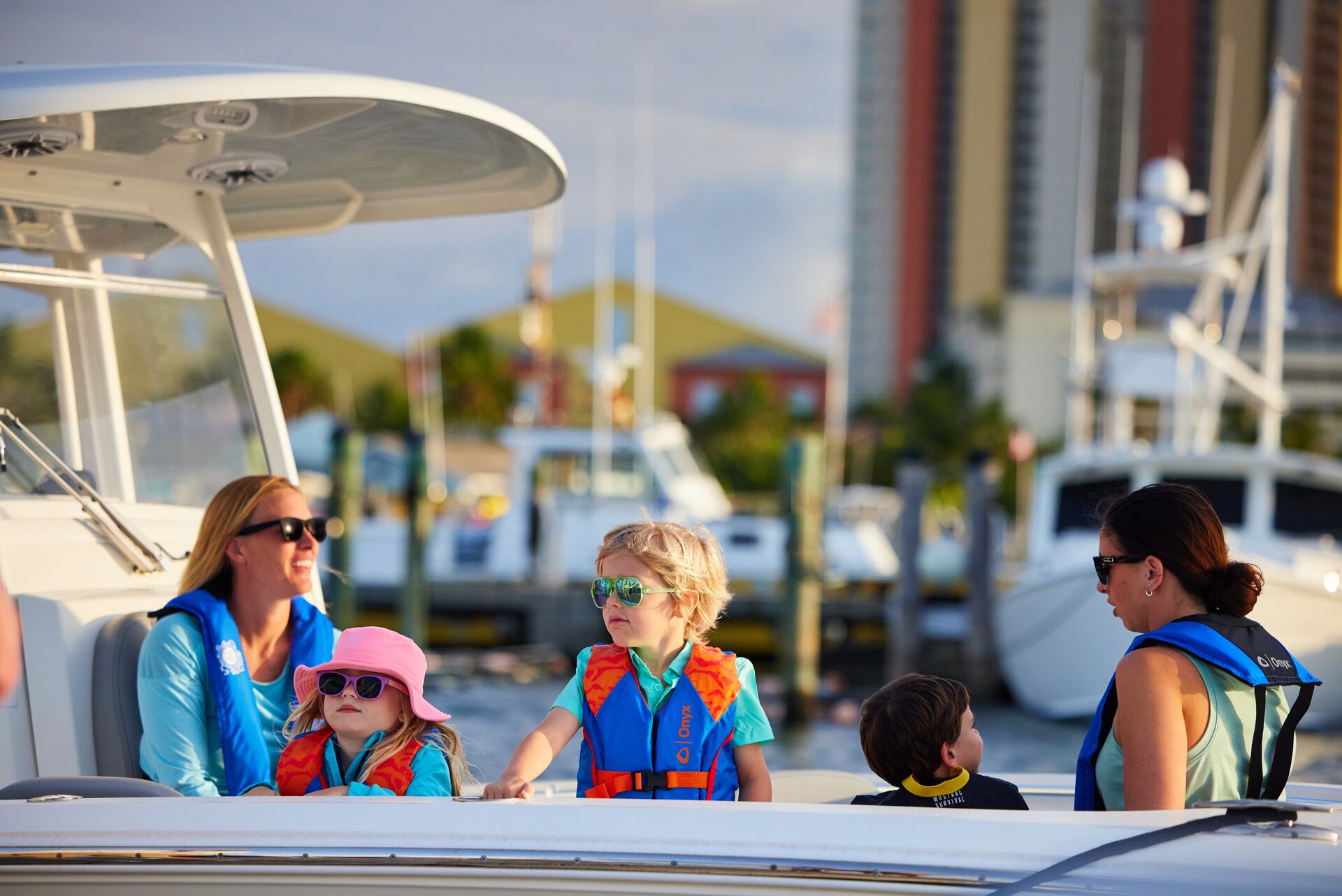 Women and children wearing lifejackets on a boat, boat safety concept. 